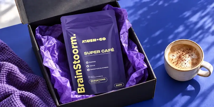 Busta di Brainstoorm di Mush N Go in una scatola nera aperta con carta velina viola, accanto a una tazza con schiuma su sfondo blu
