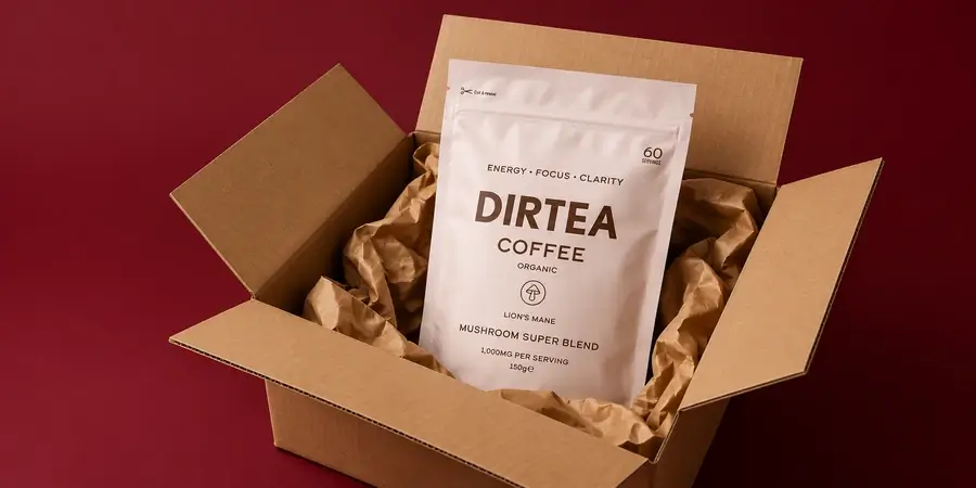 Busta di DIRTEA Coffee in un pacco di cartone aperto su sfondo bordeaux